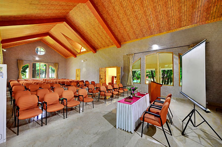 Banquet hall set theatre-style with a projector screen, stage and podium ready for a corporate town hall
