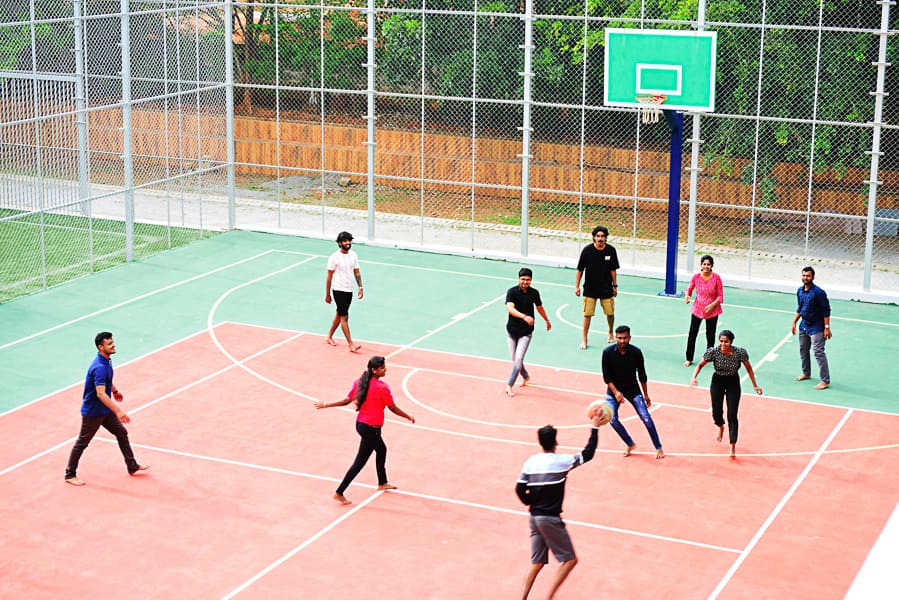 Employees playing basketball on the court during an offsite