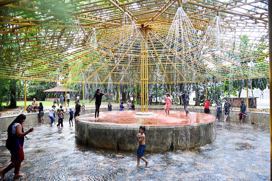 Rain dance in action with the sprinklers on and a crowd dancing to music