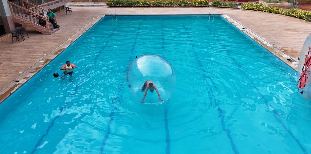 Water zorbing in the pool with a guest inside the floating ball