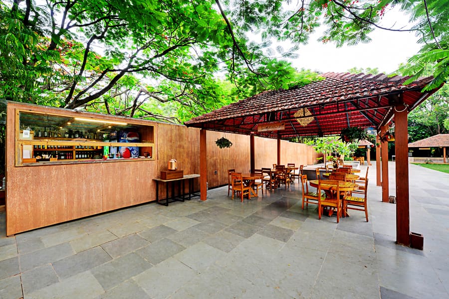 The garden dining pavilion with laid tables beside the lawn