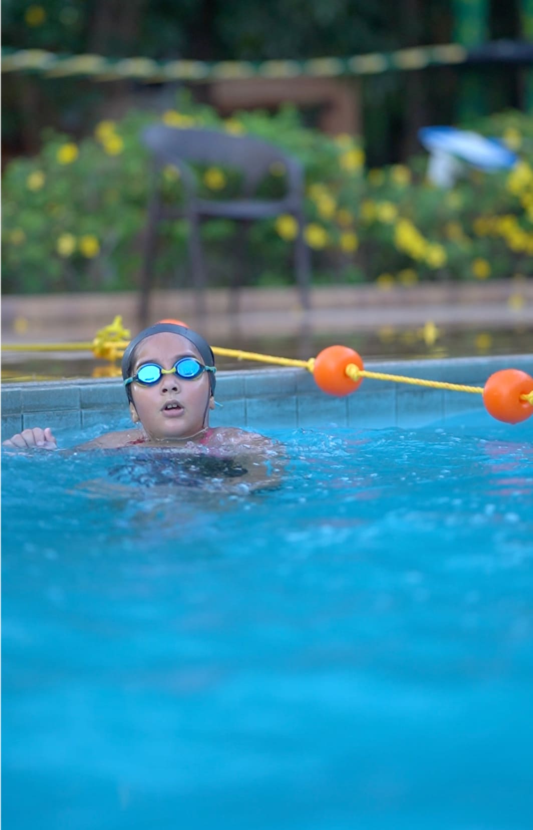 A child swimming laps in the pool, goggles on