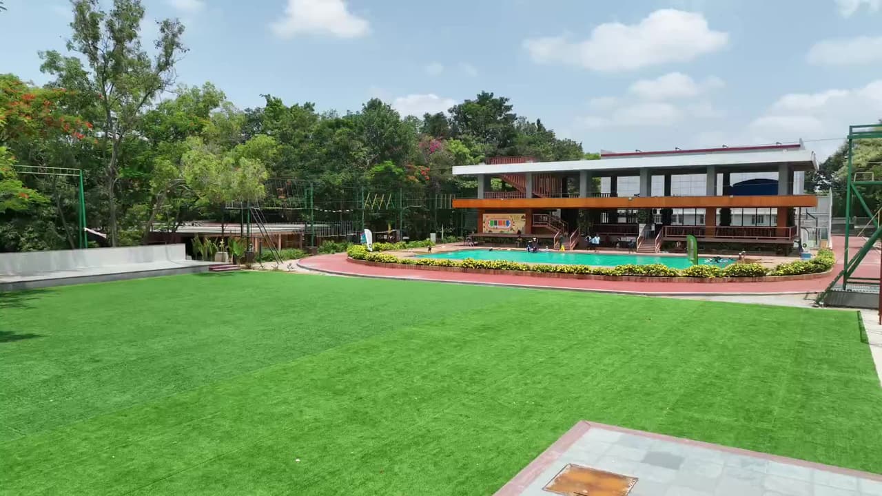 Aerial view across the main lawn to the swimming pool and clubhouse at Gold Coins Club & Resort, Electronic City