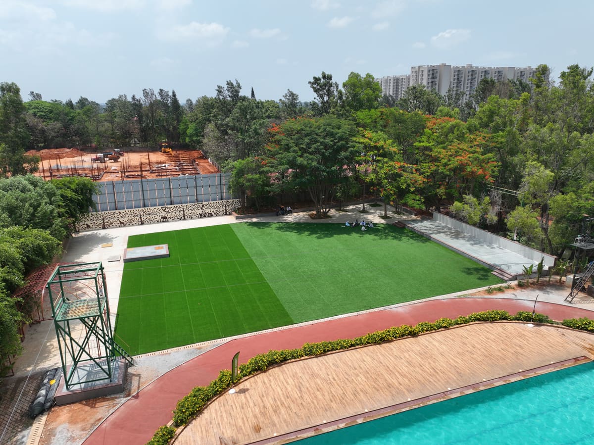 Wide shot of the resort grounds, pool and lawns, the view guests from Electronic City arrive to