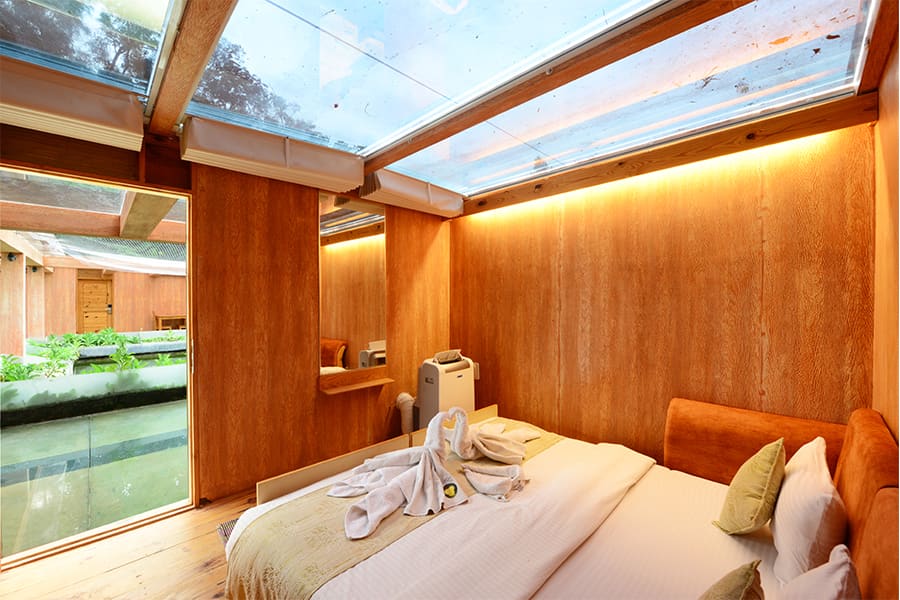 The Aqua Room king bed with the water visible through the window behind