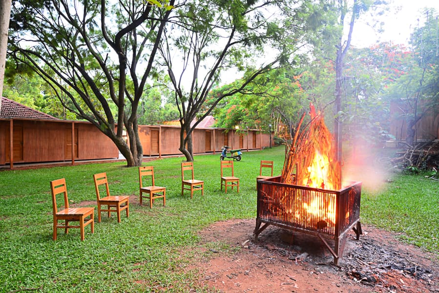The bonfire lit beside the Camping Rooms with chairs set around it