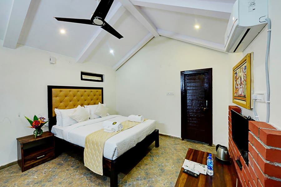 The queen bed inside the Heritage Cottage, compact room with the wardrobe alongside