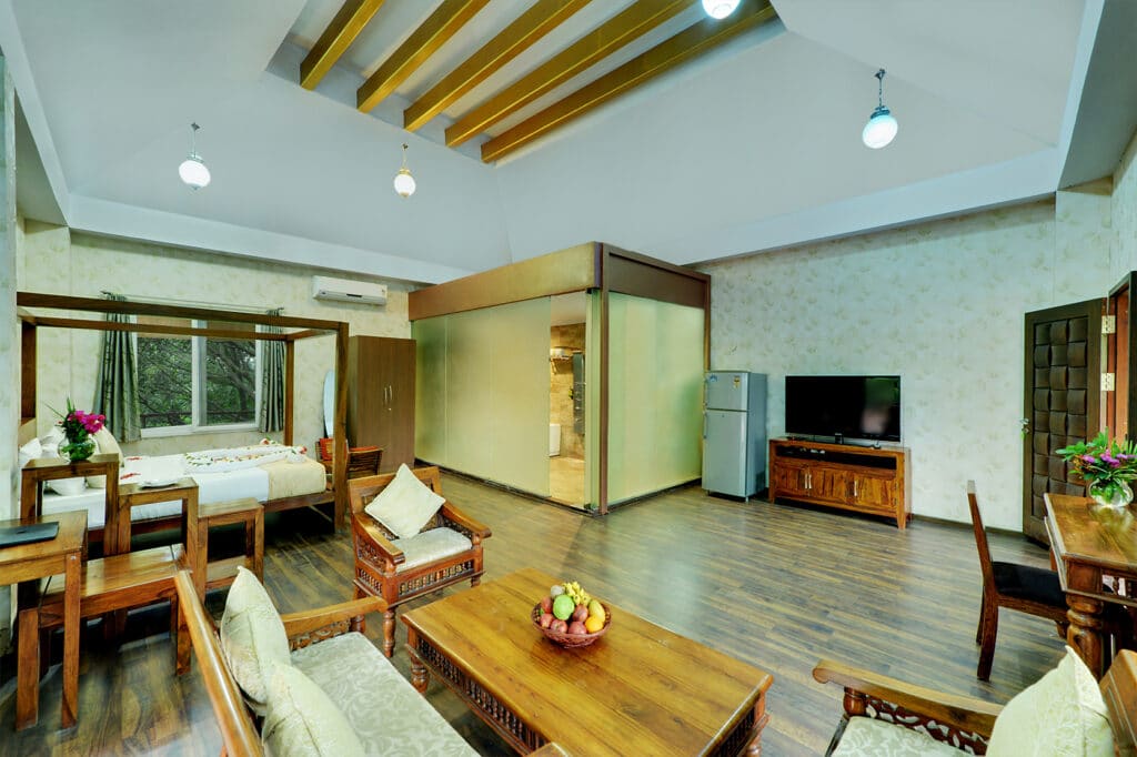 The sitting and dining corner of the Sky Room with sofa, table and the bed beyond