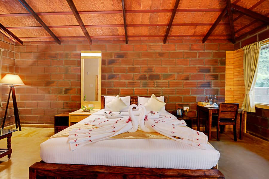 The separate sitting area of the suite, sofa and low table, bed visible through the opening