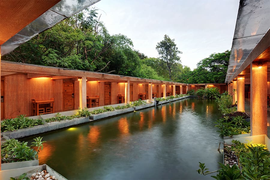 The Aqua Rooms beside their water court at dusk