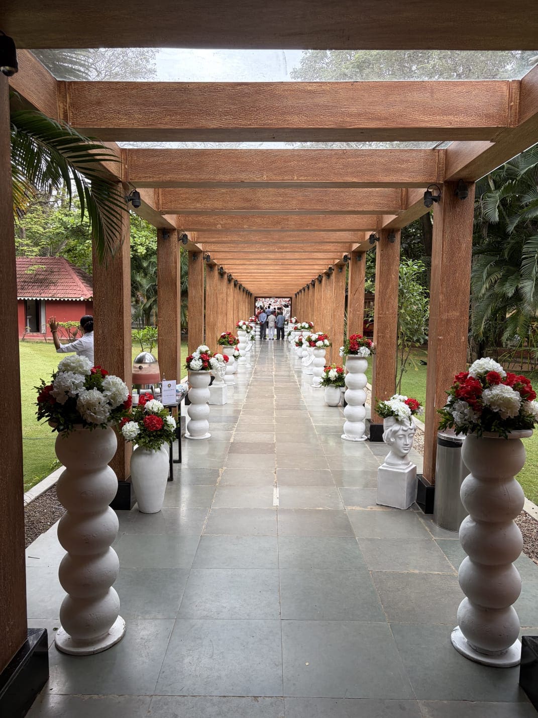 Glass House pavilion set for an intimate function, one long table, greenery visible through the glass walls